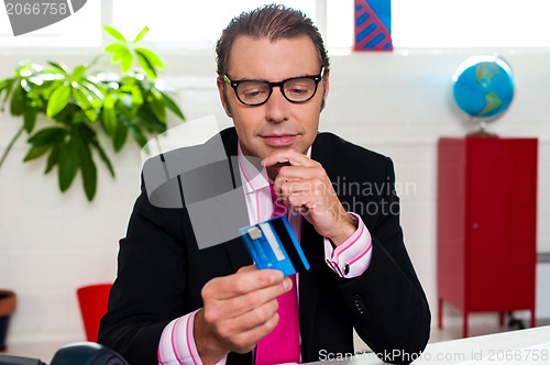 Image of Corporate man staring at his credit card