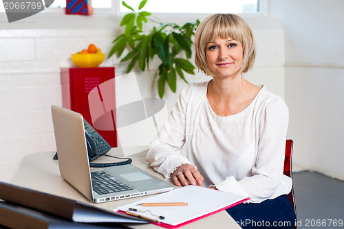 Image of Casual portrait of a woman seated at her work place