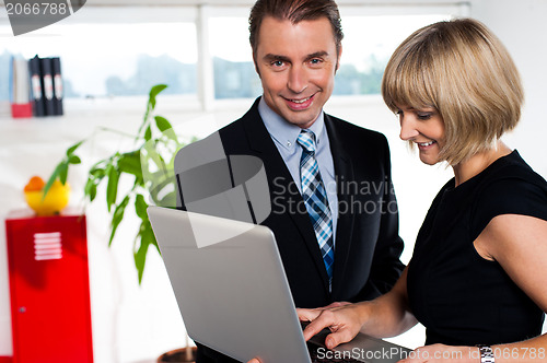 Image of Secretary showing power point presentation to the boss