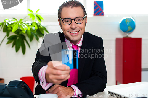 Image of Smiling business executive displaying credit card