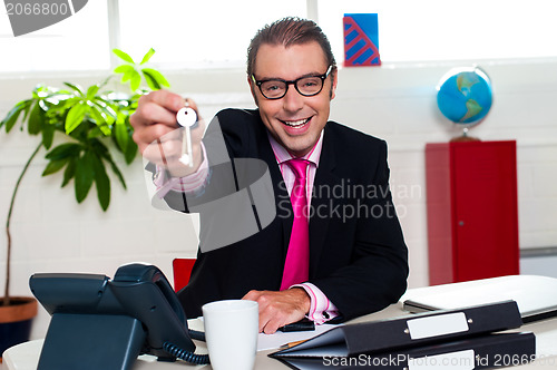 Image of Happy male executive handing over the keys