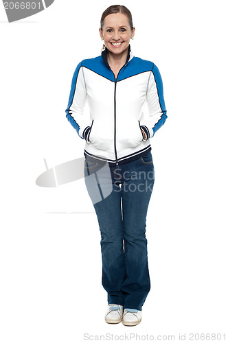 Image of Stylish woman posing with hands in jackets pocket