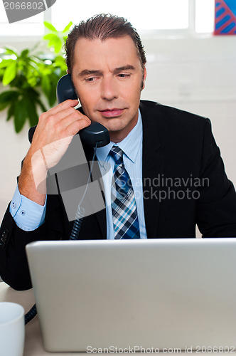 Image of Man in formal attire talking on the phone