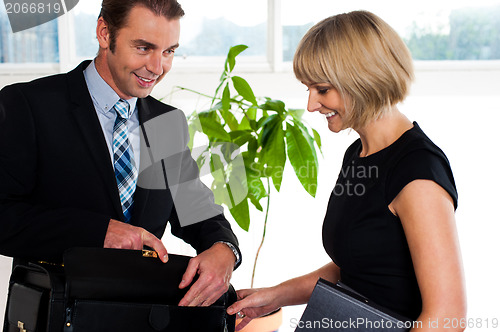 Image of Boss opening his briefcase in front of secretary