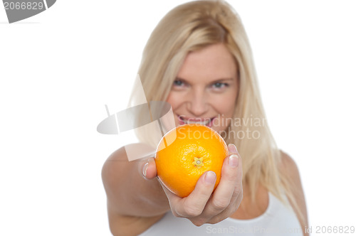 Image of Gorgeous woman with an orange in her outstretch arm