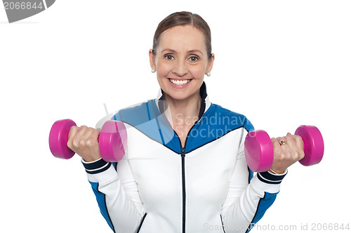 Image of Happy woman carrying dumbbells in both hands