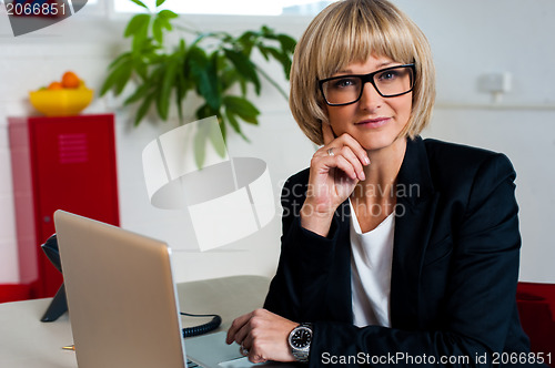 Image of Thoughtful business lady seated in office