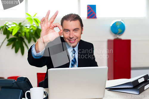 Image of Cheerful handsome manager gesturing perfect sign