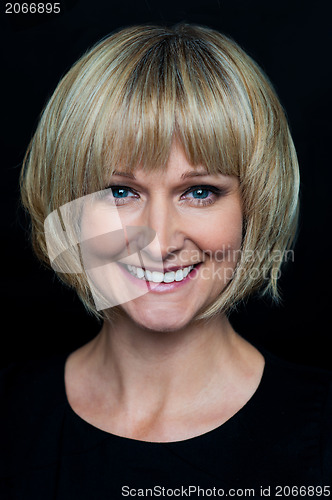 Image of Cheerful blonde woman on black background