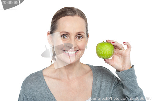 Image of Health conscious woman holding fresh green apple