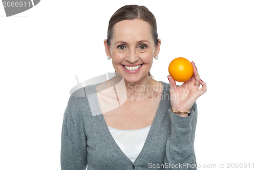 Image of Portrait of a woman holding up an orange
