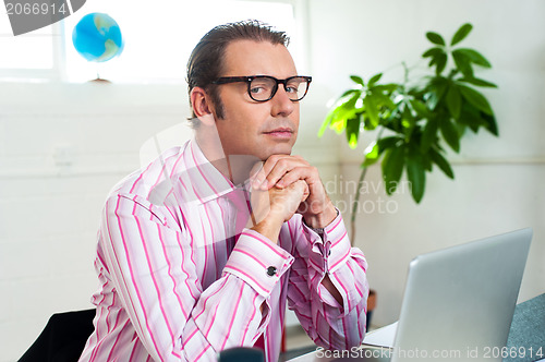 Image of Idle corporate guy in office looking sideways