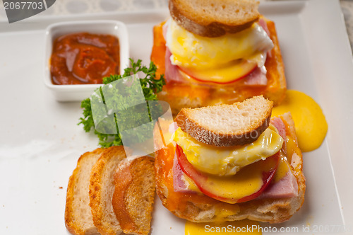 Image of eggs benedict on bread with tomato and ham