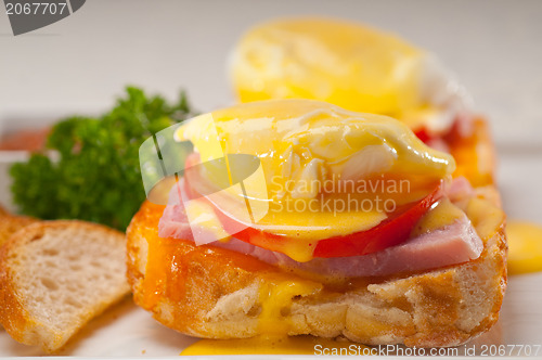 Image of eggs benedict on bread with tomato and ham