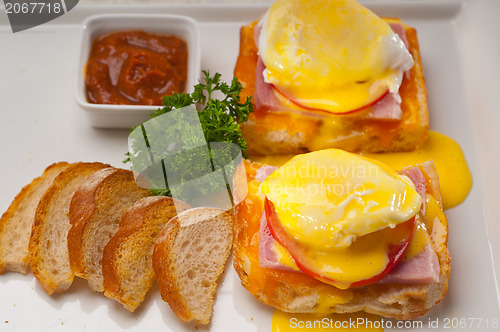 Image of eggs benedict on bread with tomato and ham