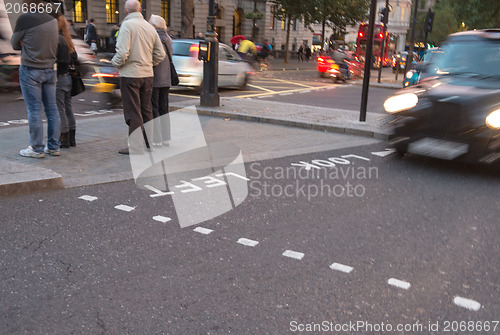 Image of Motion blur picture of Black Taxi approaching Look Right sign in