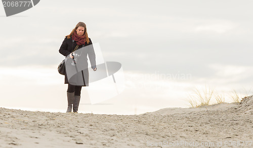 Image of Lonely photographer walking on a beach