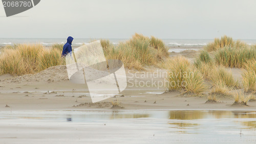 Image of Lonely woman walking on a beach