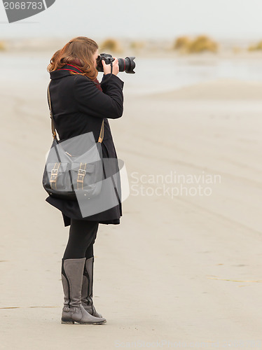 Image of Lonely photographer walking on a beach