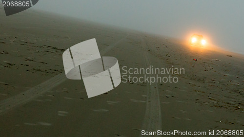 Image of Car headlights of a car on the beach