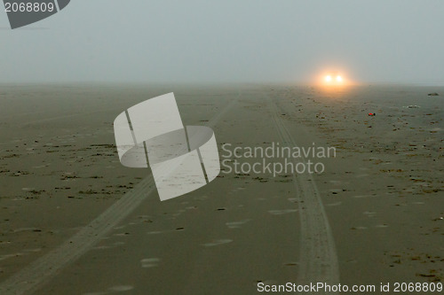 Image of Car headlights of a car on the beach