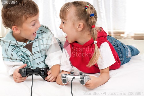 Image of Happy girl and boy playing a video game