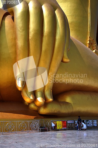 Image of Hand of Biggest Golden Buddha in thai temple of in Thailand and three monks 