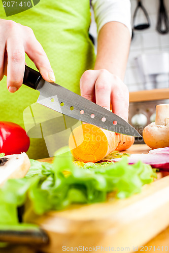 Image of Woman's hands cutting vegetables