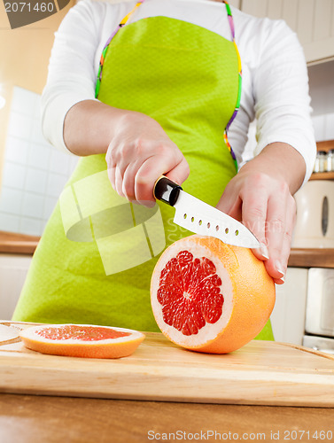 Image of Woman's hands cutting grapefruit
