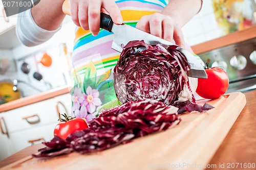 Image of Woman's hands cutting red cabbage