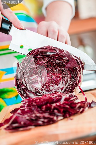 Image of Woman's hands cutting red cabbage