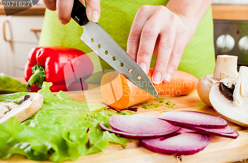 Image of Woman's hands cutting vegetables