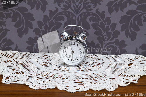 Image of Antique alarm clock on table cloth 