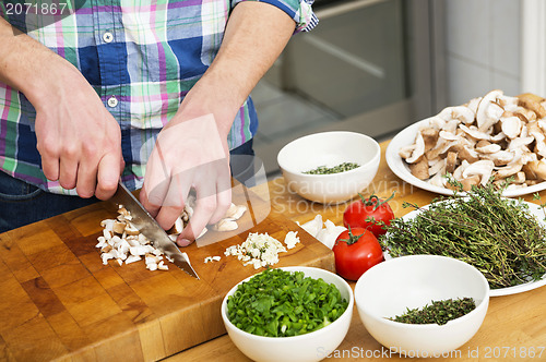 Image of Man Chopping Mushrooms With Vegetables On Counter