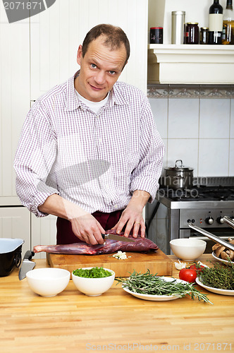 Image of Man Preparing Meat At Kitchen Counter