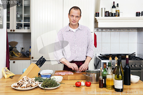 Image of Man Preparing Meat At Kitchen Counter