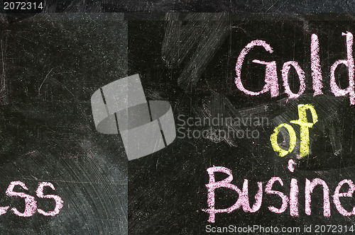 Image of GOLD OF BUSINESS handwritten with white chalk on a blackboard