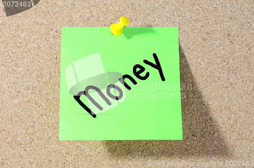 Image of The word MONEY Note paper with push pins on noticeboard 