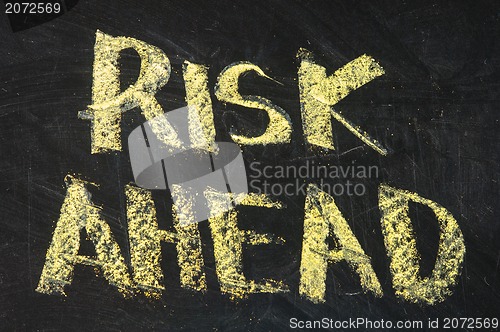 Image of risks ahead sign on black board