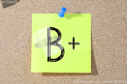 Image of B+ grade written on a test paper. 