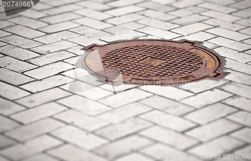 Image of Rusty manhole in the pavement