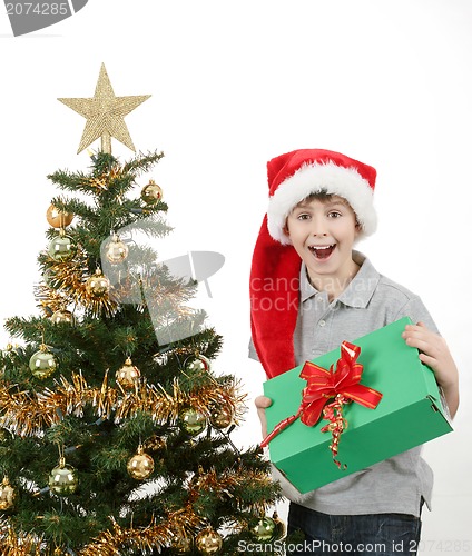 Image of happy boy in santa hat surprised by christmas present