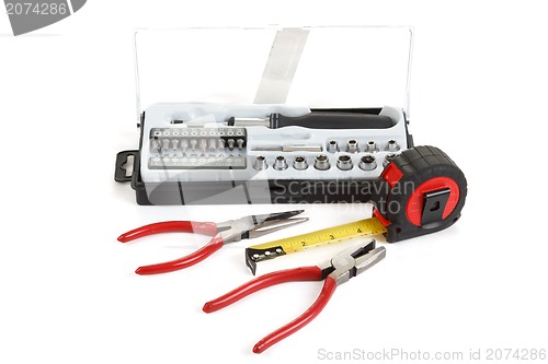 Image of screwdriver toolbox with set of bits, pliers and measuring tape