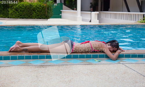 Image of Slender brunette lying by the pool