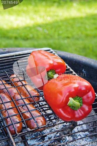 Image of Red sweet pepper and sausages on a grill