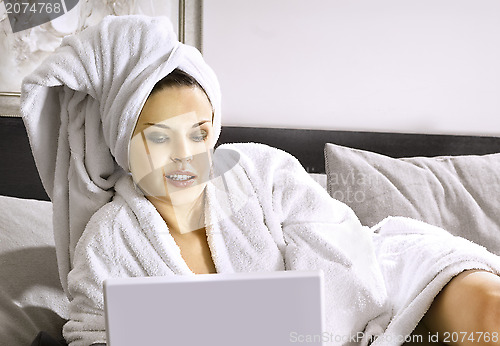 Image of Lady with laptop on bed