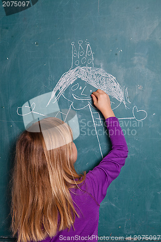 Image of Young girl drawing on chalkboard