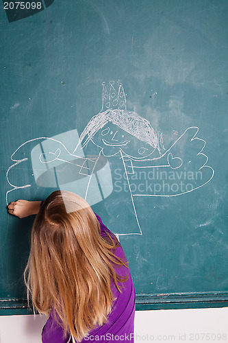 Image of Young girl drawing on chalkboard