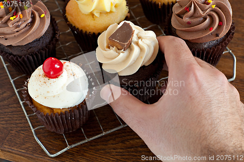 Image of Person Choosing a Cupcake