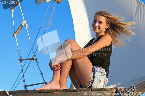 Image of teen girl sitting at stern of the ship